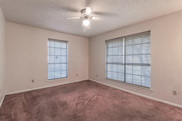 carpeted spare room featuring a textured ceiling and ceiling fan