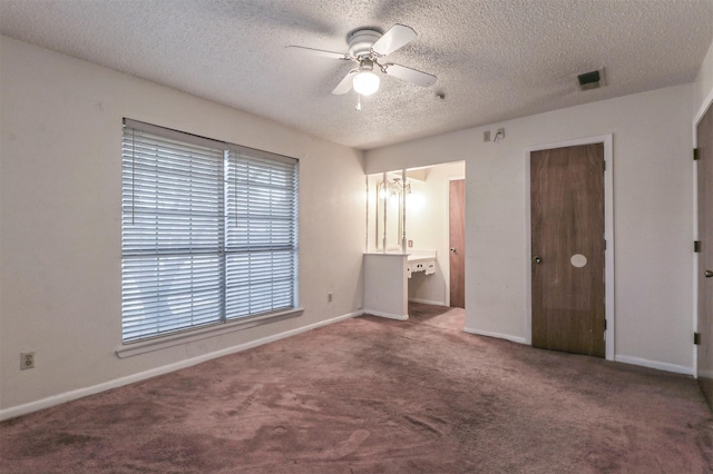 unfurnished bedroom with ceiling fan, ensuite bath, carpet floors, and a textured ceiling