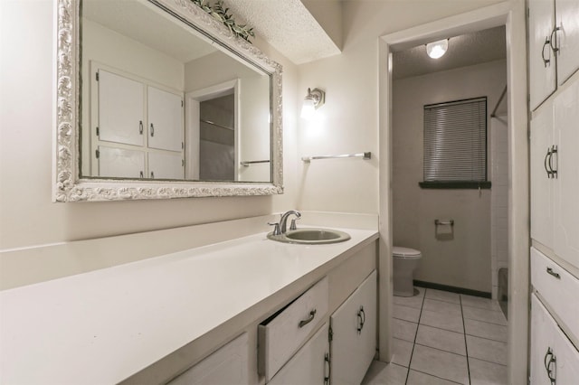 bathroom with tile patterned flooring, vanity, toilet, and a textured ceiling