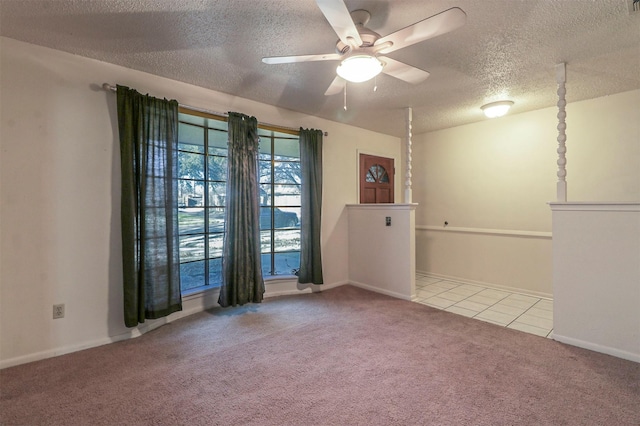 spare room with light carpet, ceiling fan, and a textured ceiling