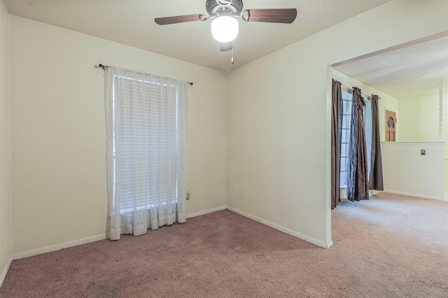 carpeted empty room featuring ceiling fan and a textured ceiling