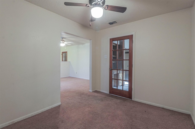 carpeted spare room with ceiling fan and a textured ceiling