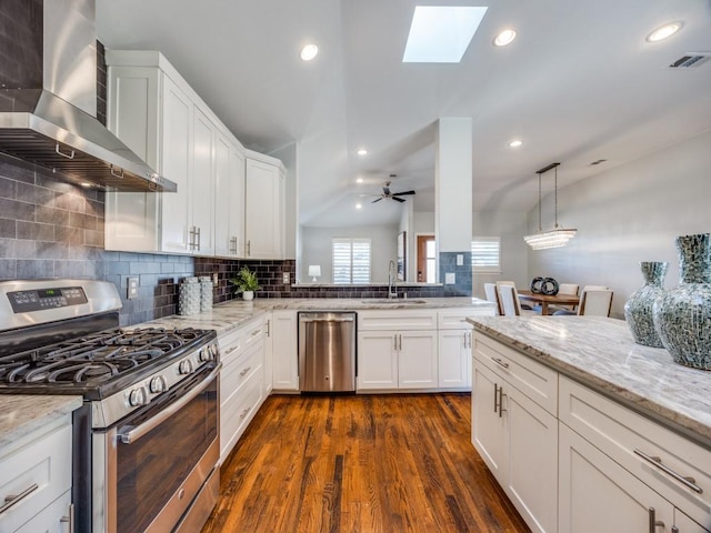 kitchen with white cabinets, sink, wall chimney exhaust hood, and appliances with stainless steel finishes