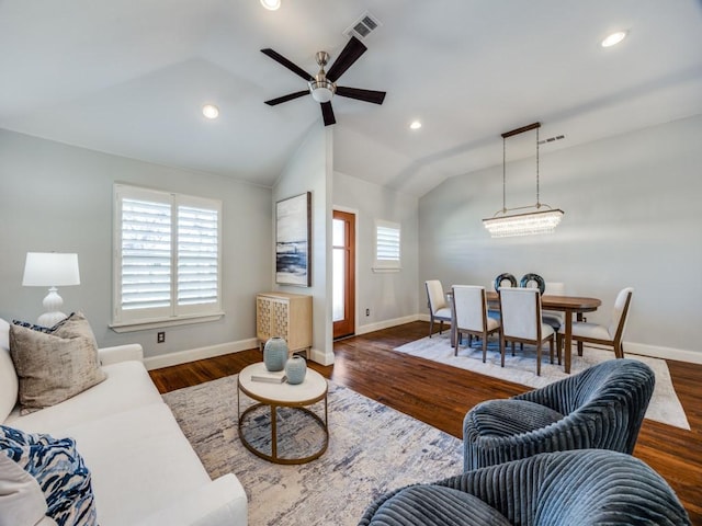 living room featuring dark wood-type flooring, ceiling fan, plenty of natural light, and vaulted ceiling