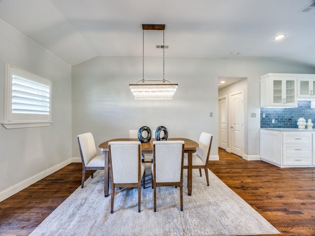 dining room featuring lofted ceiling and dark wood-type flooring