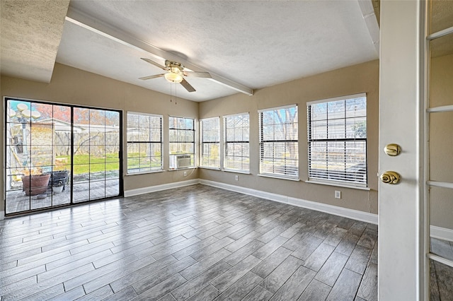 unfurnished sunroom featuring ceiling fan