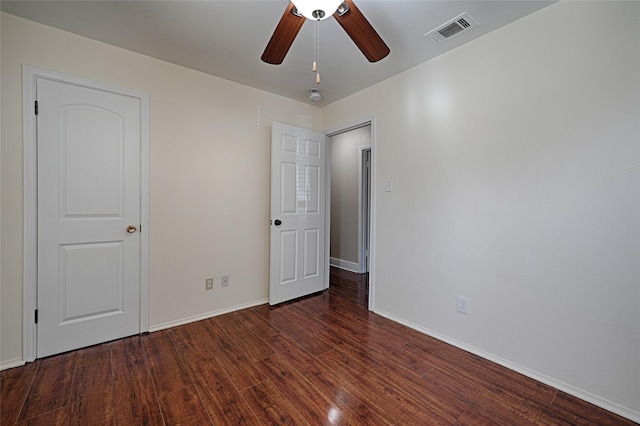 empty room featuring ceiling fan and dark hardwood / wood-style flooring