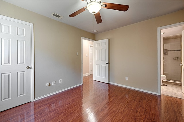 unfurnished bedroom featuring dark wood-type flooring, ceiling fan, and ensuite bath