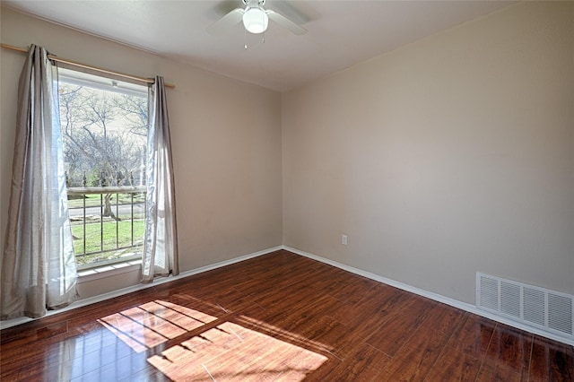 spare room featuring dark wood-type flooring and ceiling fan