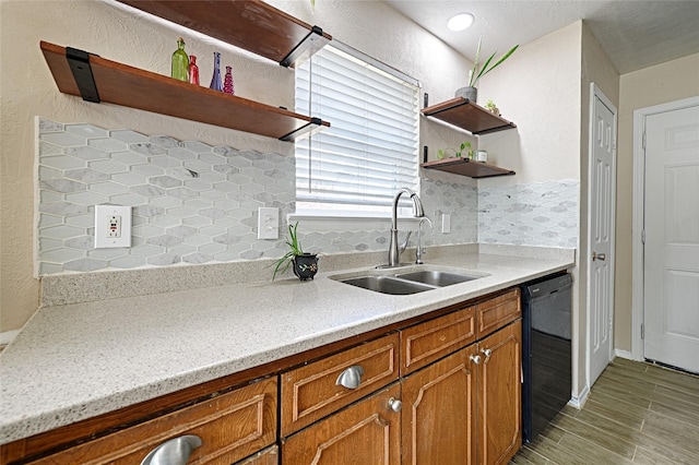 kitchen with dishwasher, light stone countertops, sink, and backsplash