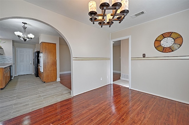 interior space with light wood-type flooring and an inviting chandelier