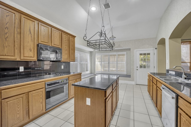 kitchen with lofted ceiling, sink, a center island, decorative backsplash, and black appliances