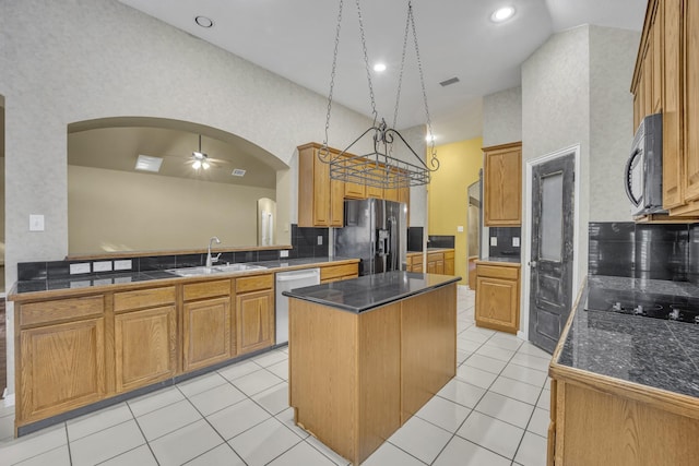 kitchen featuring sink, light tile patterned floors, a kitchen island, decorative backsplash, and black appliances