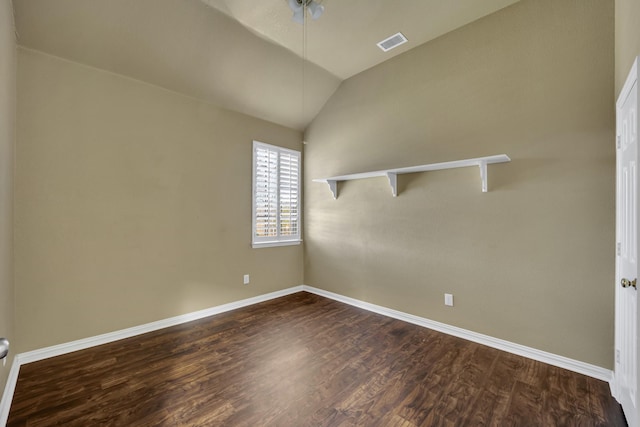 spare room featuring lofted ceiling and dark hardwood / wood-style floors