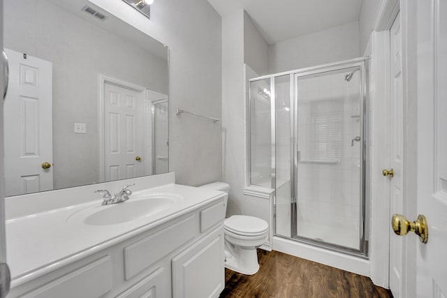 bathroom featuring vanity, hardwood / wood-style floors, toilet, and walk in shower