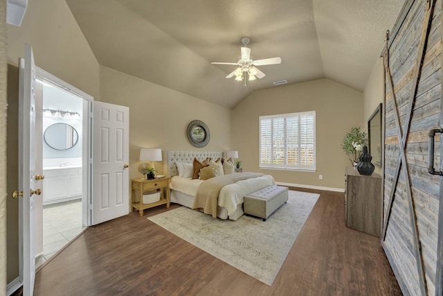 bedroom featuring ceiling fan, dark hardwood / wood-style flooring, vaulted ceiling, and ensuite bath