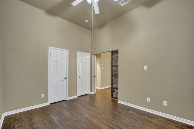 unfurnished bedroom featuring high vaulted ceiling, dark hardwood / wood-style floors, and ceiling fan