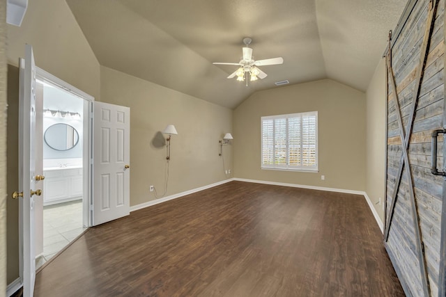 spare room featuring vaulted ceiling, dark hardwood / wood-style floors, and ceiling fan