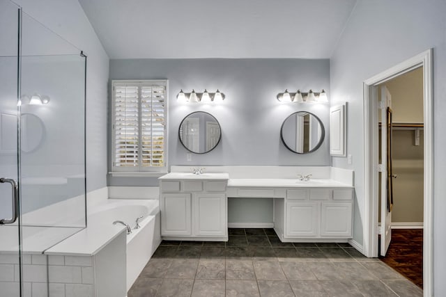 bathroom with lofted ceiling, vanity, tile patterned flooring, and plus walk in shower