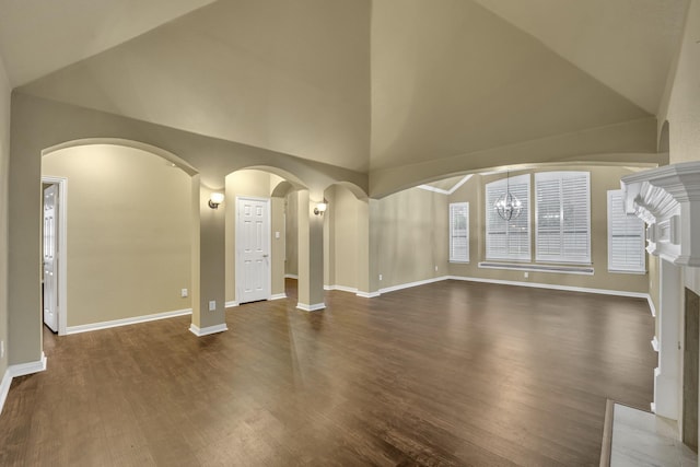 unfurnished living room featuring dark wood-type flooring and high vaulted ceiling