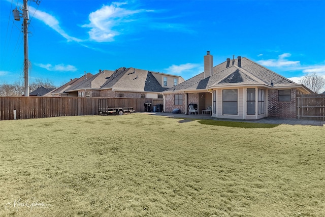 back of house with a patio area and a lawn