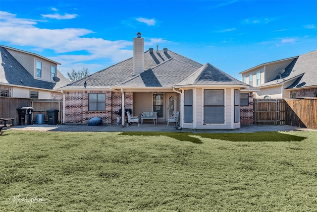 rear view of property with a yard and a patio area