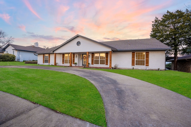 ranch-style home featuring a porch and a yard