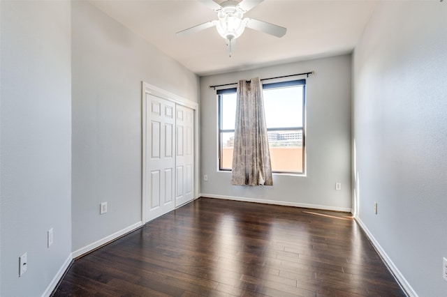 empty room with ceiling fan and dark hardwood / wood-style floors