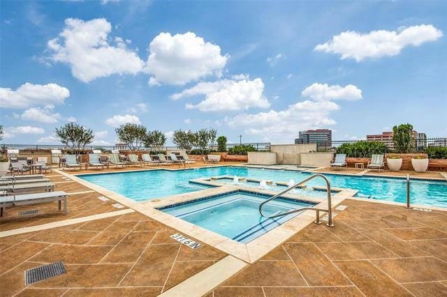 view of pool with a hot tub and a patio area