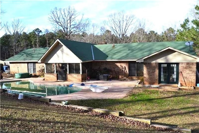 rear view of property featuring french doors, a yard, and a patio area