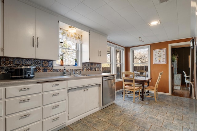 kitchen with white cabinets, backsplash, sink, and dishwasher