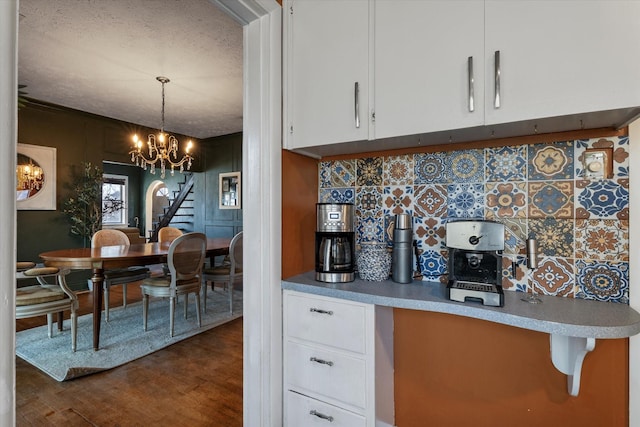 kitchen featuring tasteful backsplash, white cabinetry, dark hardwood / wood-style flooring, and decorative light fixtures