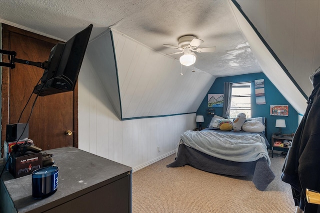 carpeted bedroom featuring ceiling fan, wooden walls, vaulted ceiling, and a textured ceiling