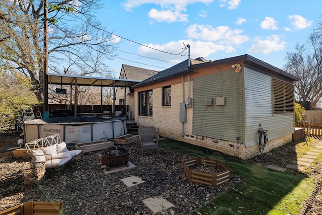 rear view of house featuring an outdoor living space with a fire pit