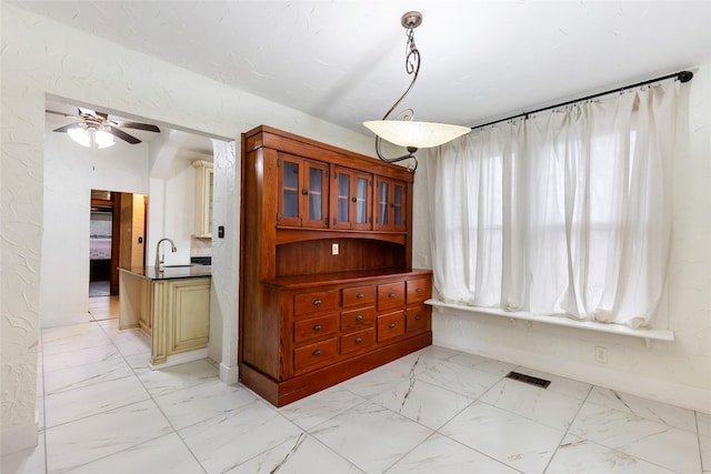 dining area with ceiling fan and sink