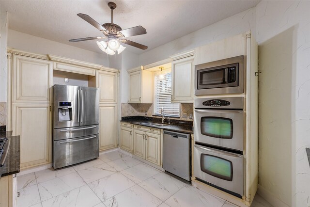 kitchen featuring sink, ceiling fan, stainless steel appliances, tasteful backsplash, and cream cabinets