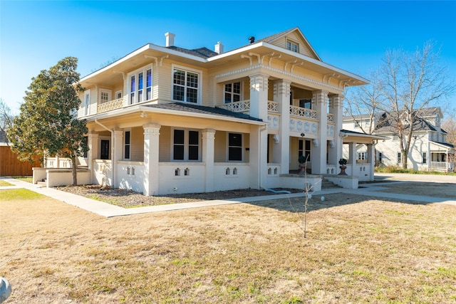 view of front of property featuring a balcony and a front yard