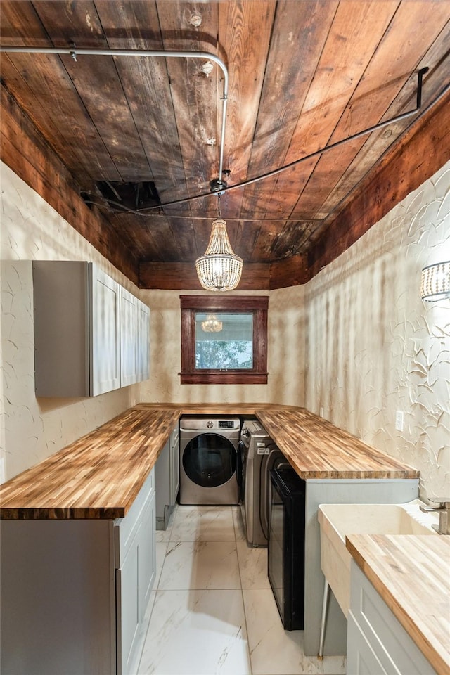 laundry area with washer and clothes dryer, a notable chandelier, and wood ceiling