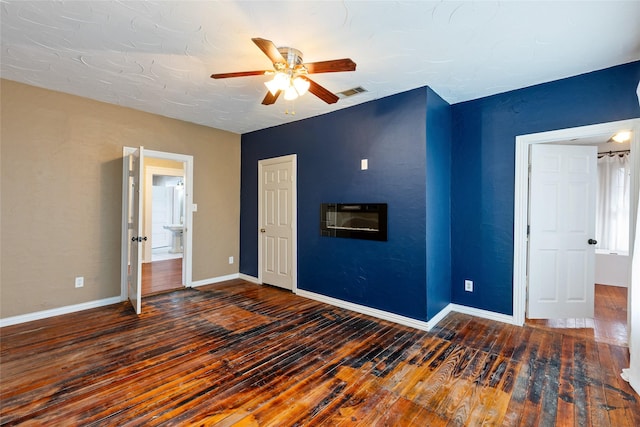 unfurnished bedroom featuring dark hardwood / wood-style floors and ceiling fan