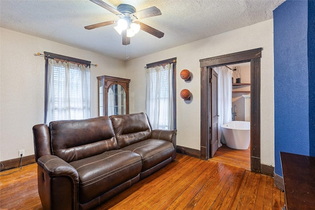 living room featuring hardwood / wood-style floors, a textured ceiling, and ceiling fan