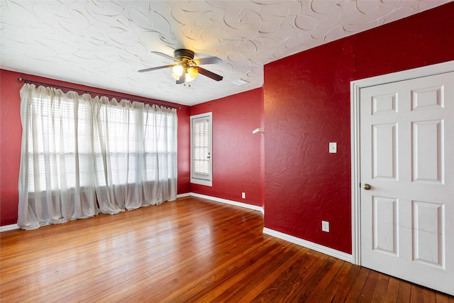 unfurnished room with ceiling fan and wood-type flooring