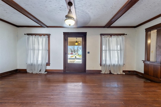 entryway with crown molding, dark hardwood / wood-style floors, a textured ceiling, and beam ceiling