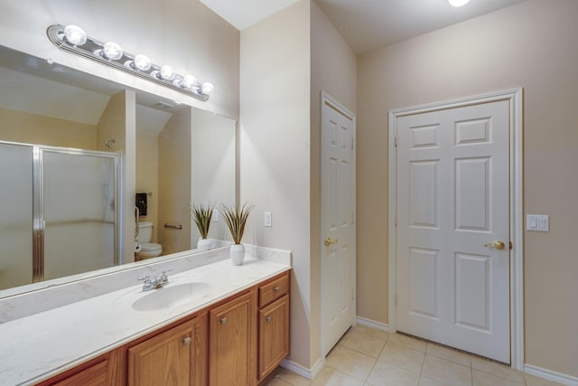 bathroom featuring walk in shower, vanity, toilet, and tile patterned flooring