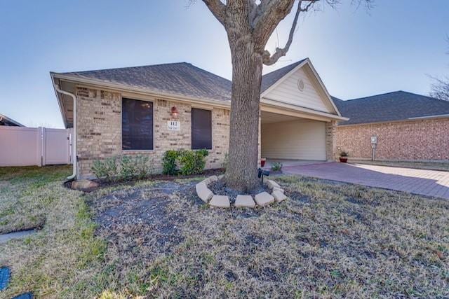 ranch-style house featuring brick siding, an attached garage, and fence