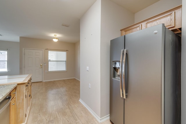 kitchen featuring plenty of natural light, light brown cabinets, light hardwood / wood-style floors, and appliances with stainless steel finishes