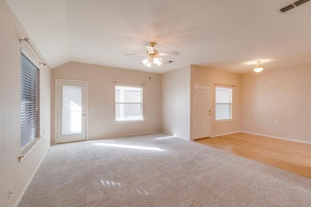 unfurnished room with lofted ceiling, light carpet, and ceiling fan