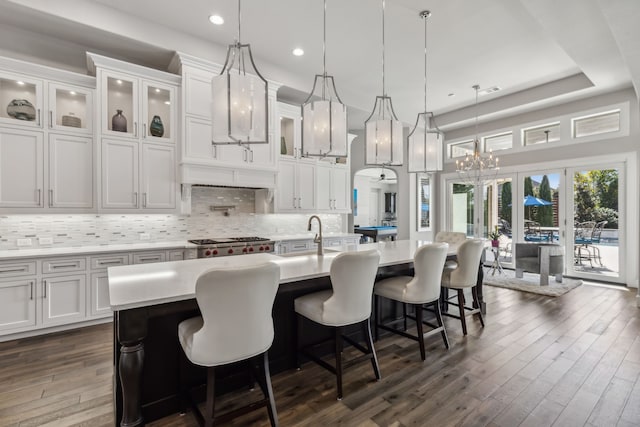 kitchen featuring a large island with sink, white cabinetry, and pendant lighting