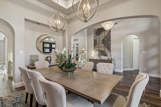 dining area featuring an inviting chandelier, ornamental molding, and dark hardwood / wood-style floors