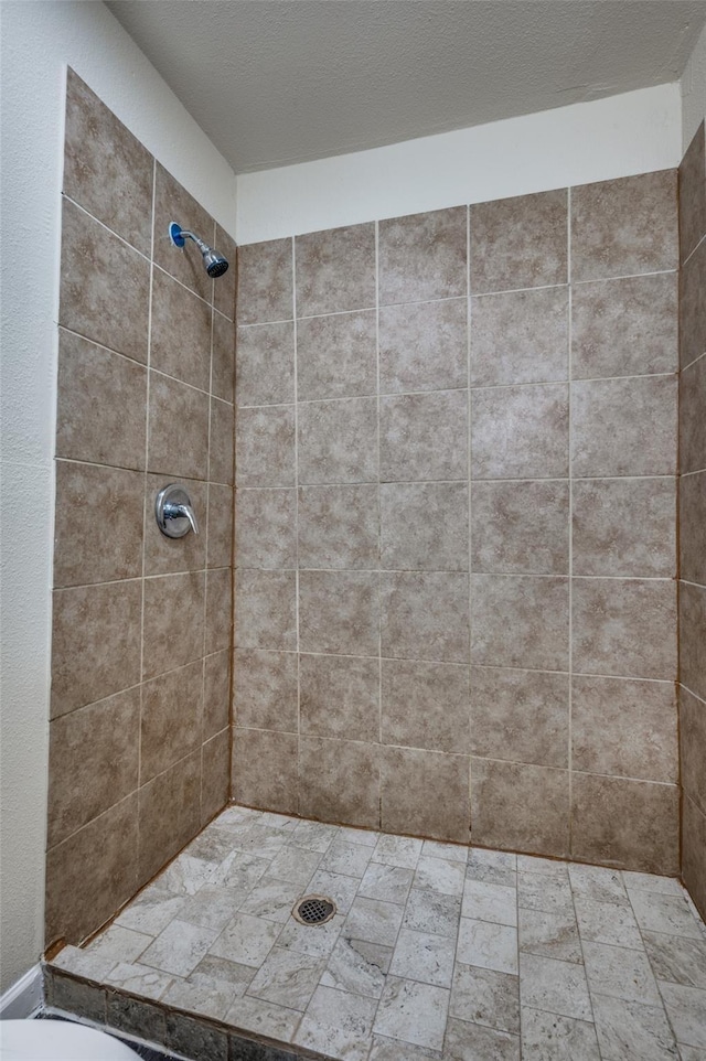 bathroom with toilet and tiled shower