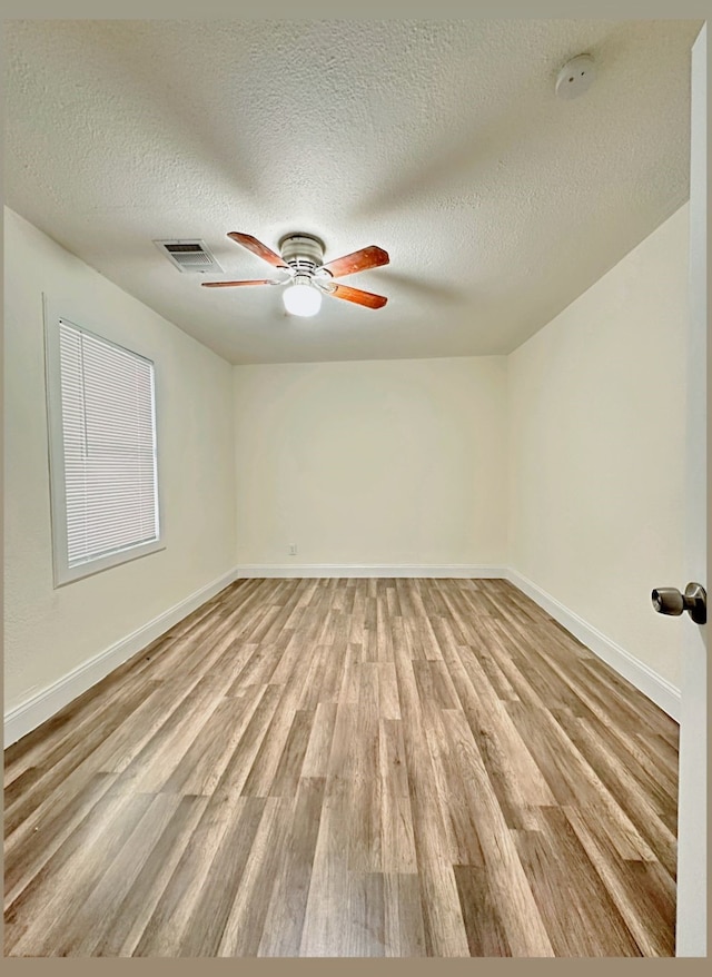 spare room with ceiling fan, a textured ceiling, and light hardwood / wood-style flooring